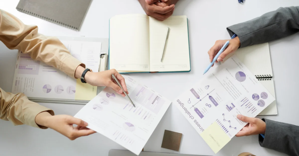 Business professionals collaborating on documents related to Salesforce Marketing Cloud strategies.